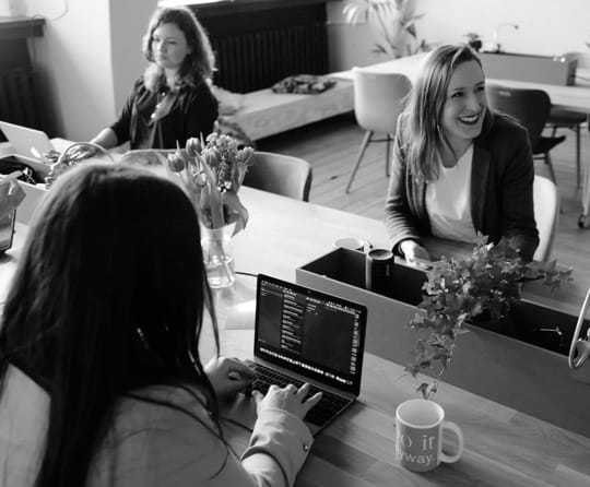 women in a room working and smiling