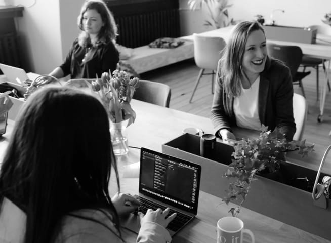 women in a room working and smiling